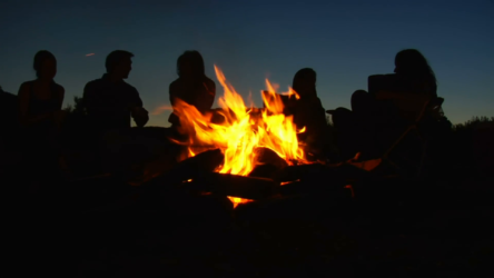 silhouettes of people sitting around campfire